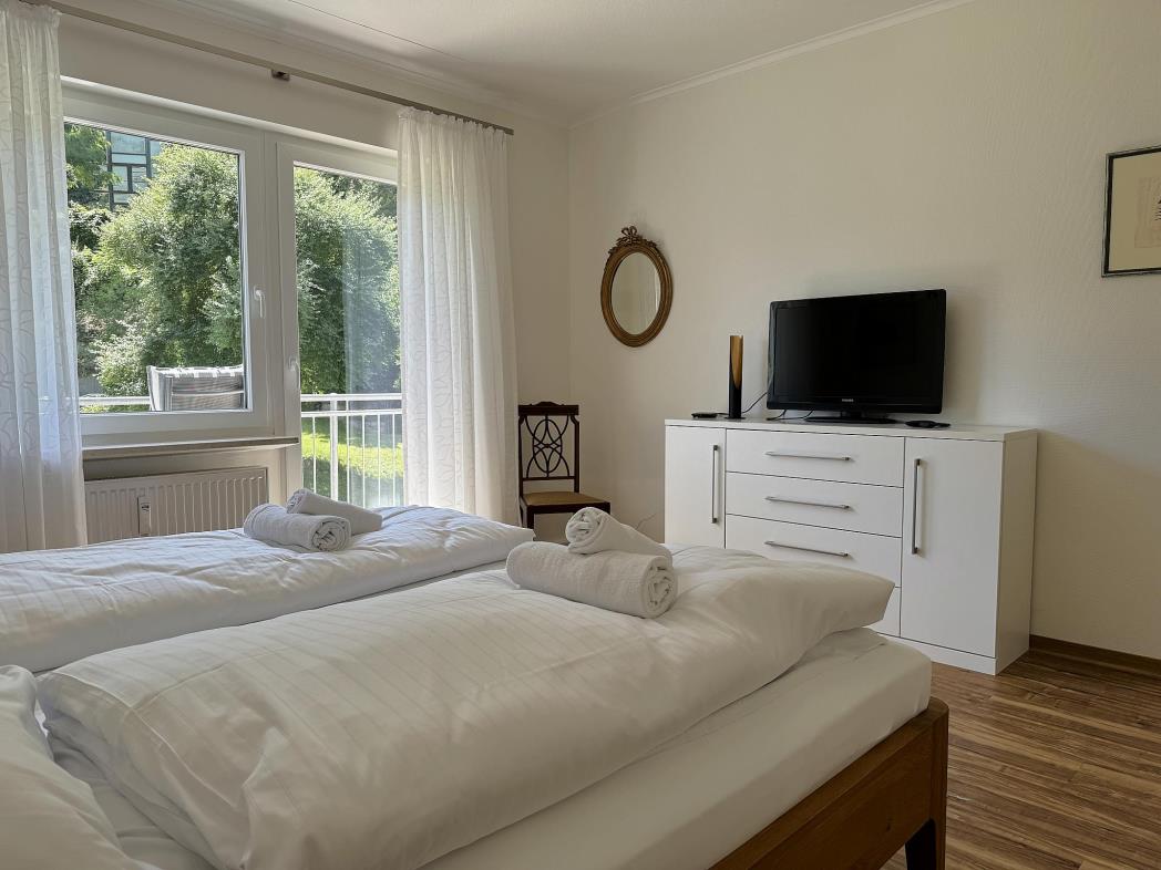Schlafzimmer mit Kommode und TV - Urlaub an der Mosel in Ferienwohnung Mosel Fewo43, Marientaler Au 43, 56856 Zell (Mosel)